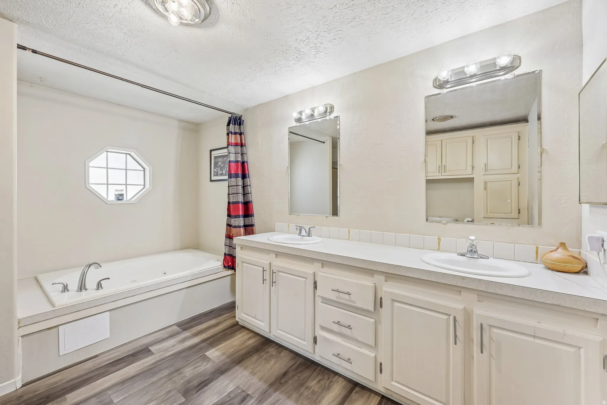 Dual vanity with white cabinetry, integrated sinks, and chrome faucets