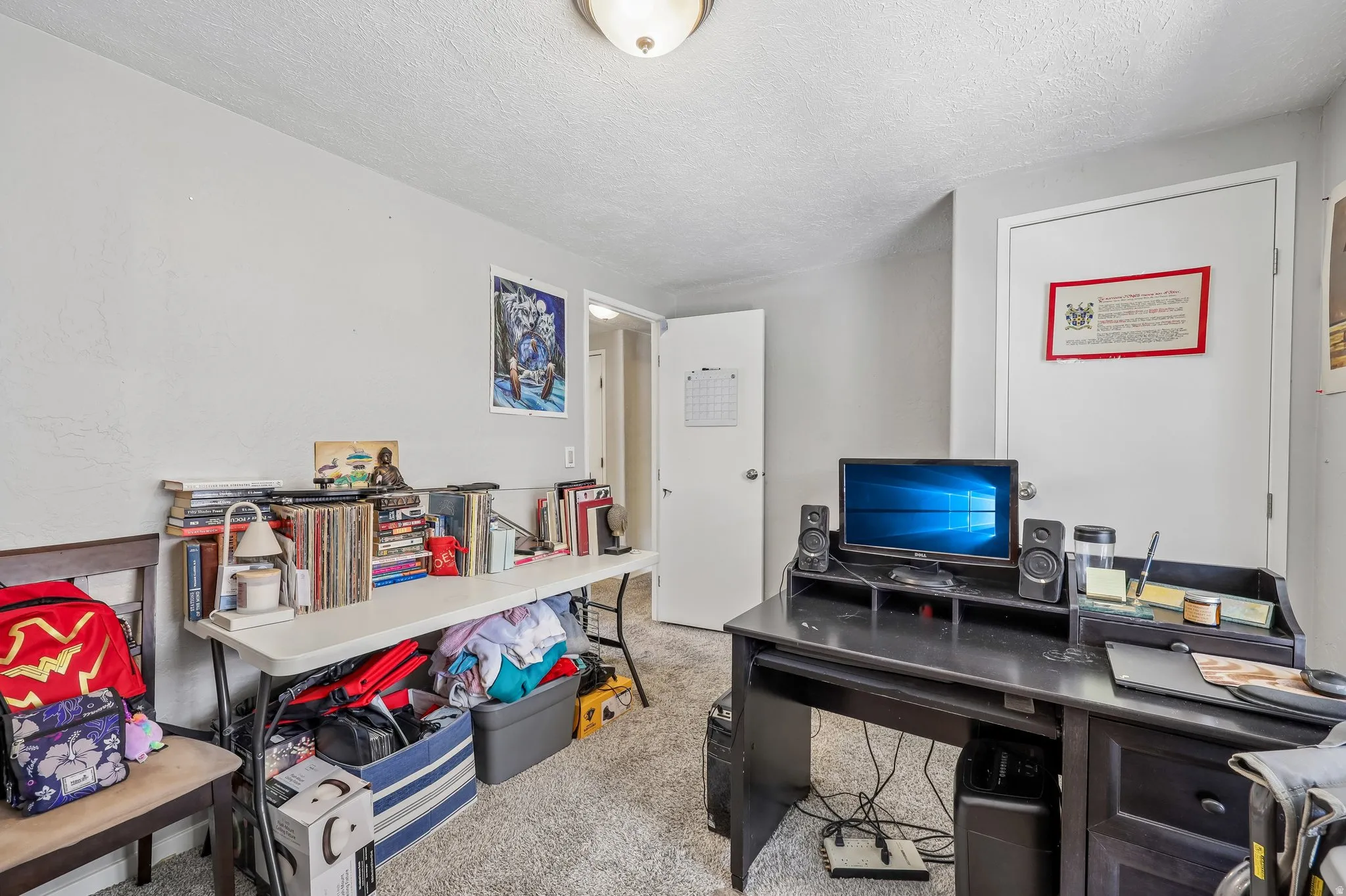 Light-colored walls with a textured ceiling and neutral carpeting