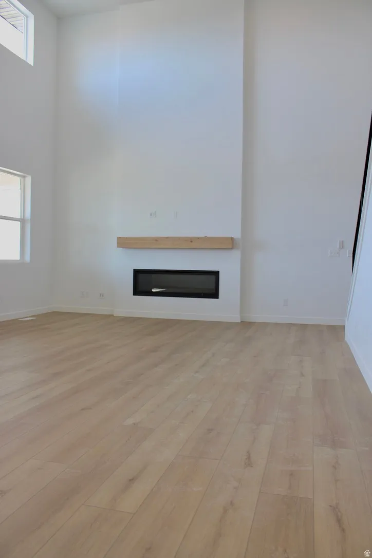 Floor-to-ceiling fireplace feature wall with a light wood-finish mantel and a linear electric fireplace