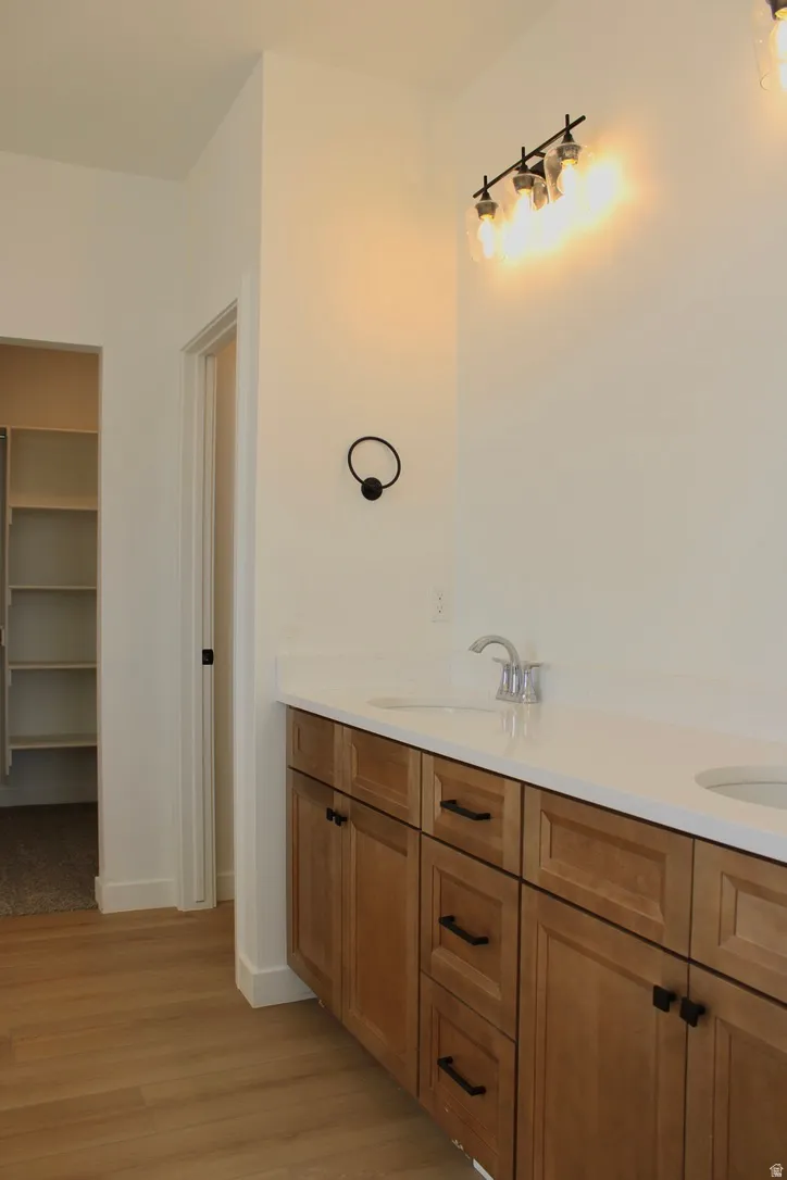 Double vanity with light wood-finish cabinetry and matte black hardware