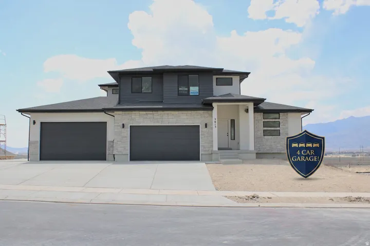 Contemporary two-story residence featuring a striking combination of light stone veneer and dark siding