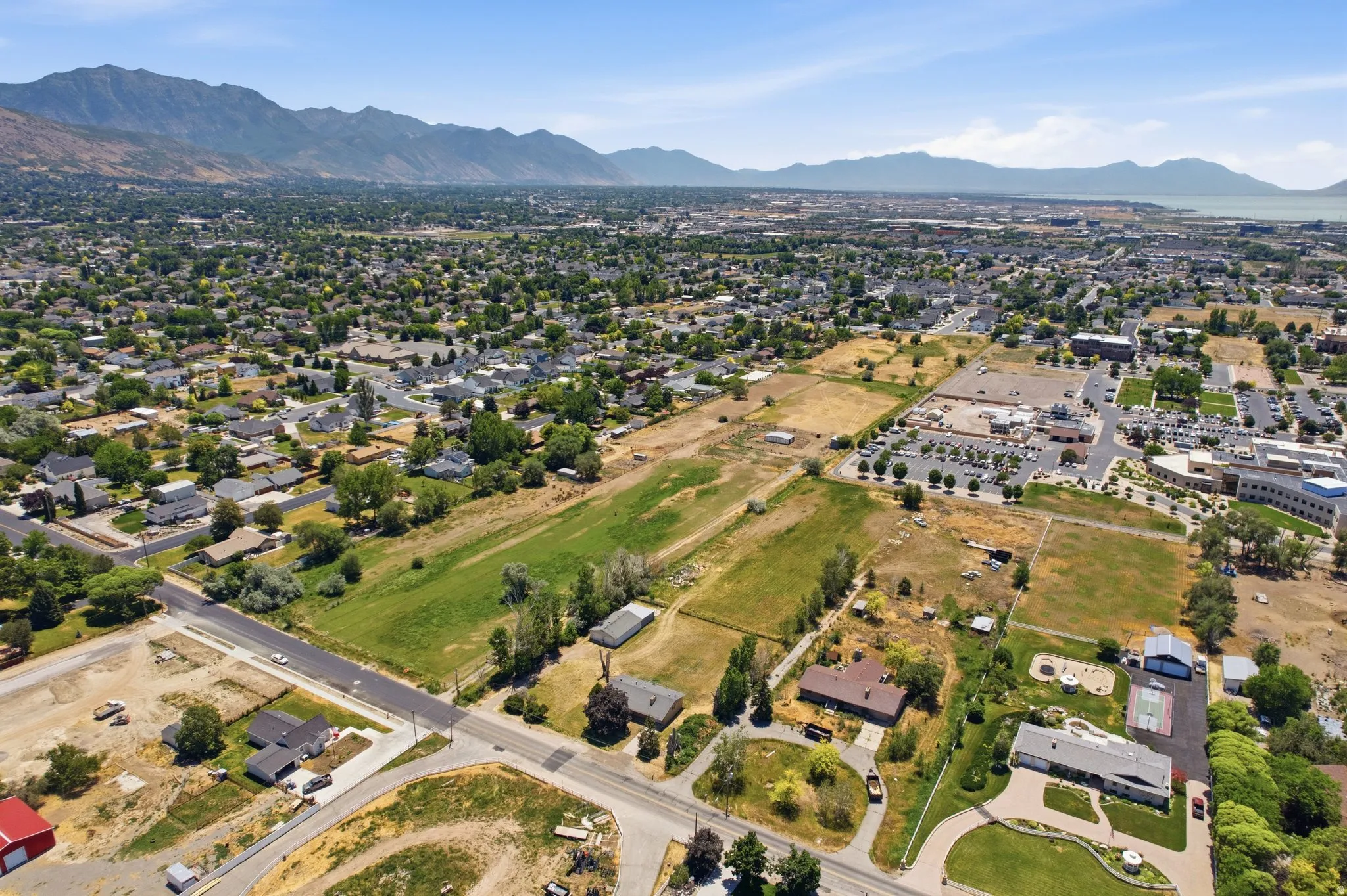 Expansive aerial view showcasing a diverse landscape with residential areas, open fields, and commercial zones