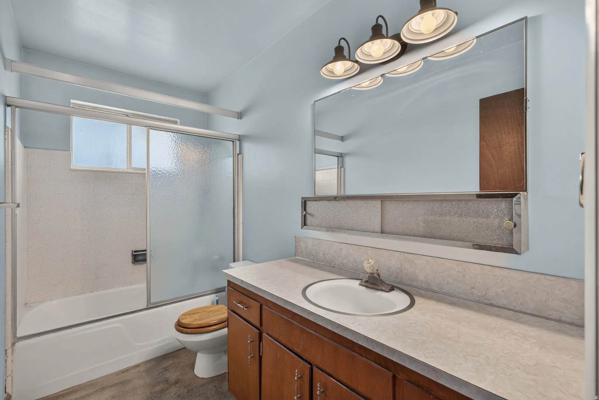 Bathroom featuring an integrated bathtub and shower with sliding glass enclosure
