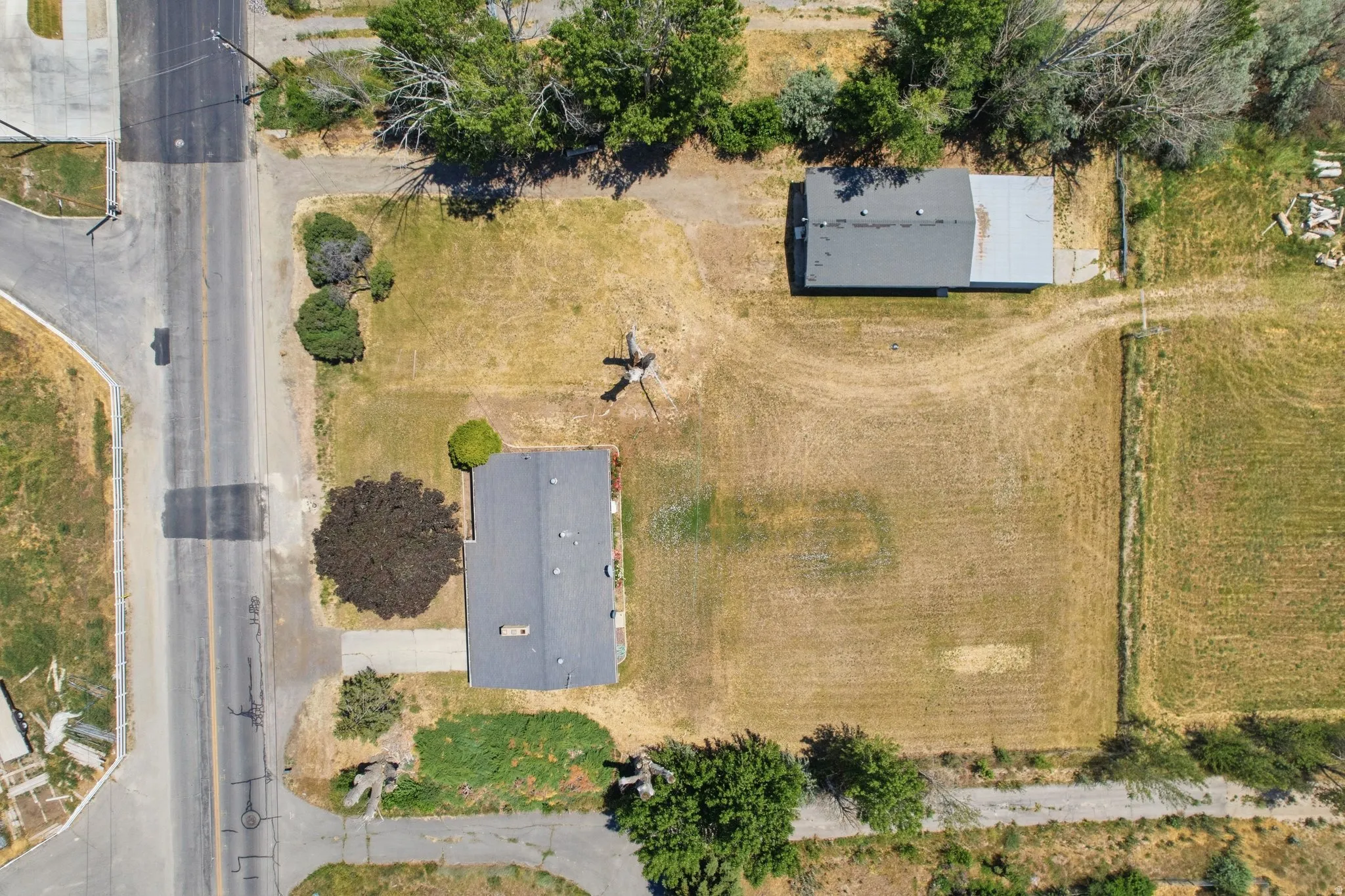Aerial perspective showcasing a single-story dwelling and a detached outbuilding on a spacious lot