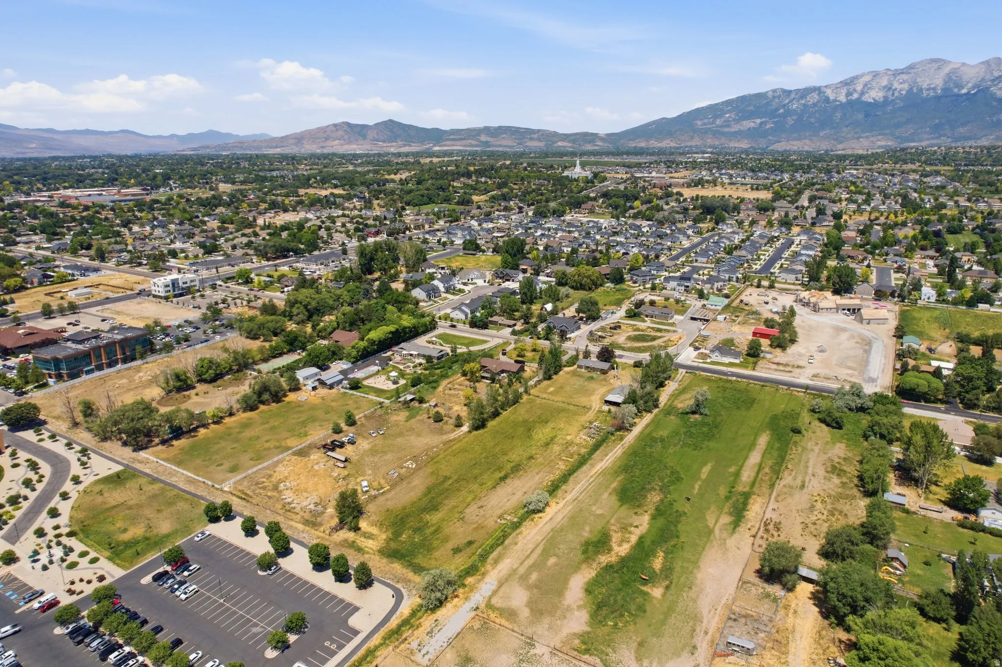 Expansive aerial showcasing a developed community with surrounding undeveloped land and mountain ranges in the distance