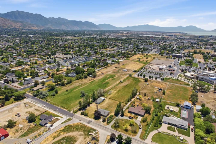 Expansive aerial view showcasing a diverse landscape with residential areas, open fields, and commercial zones