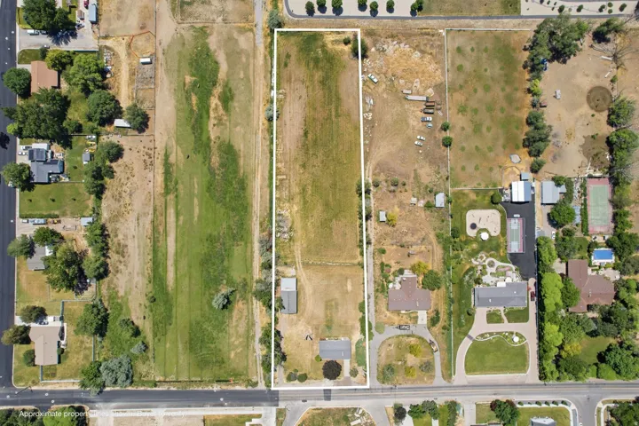 Expansive rectangular lot featuring a detached outbuilding and direct road frontage