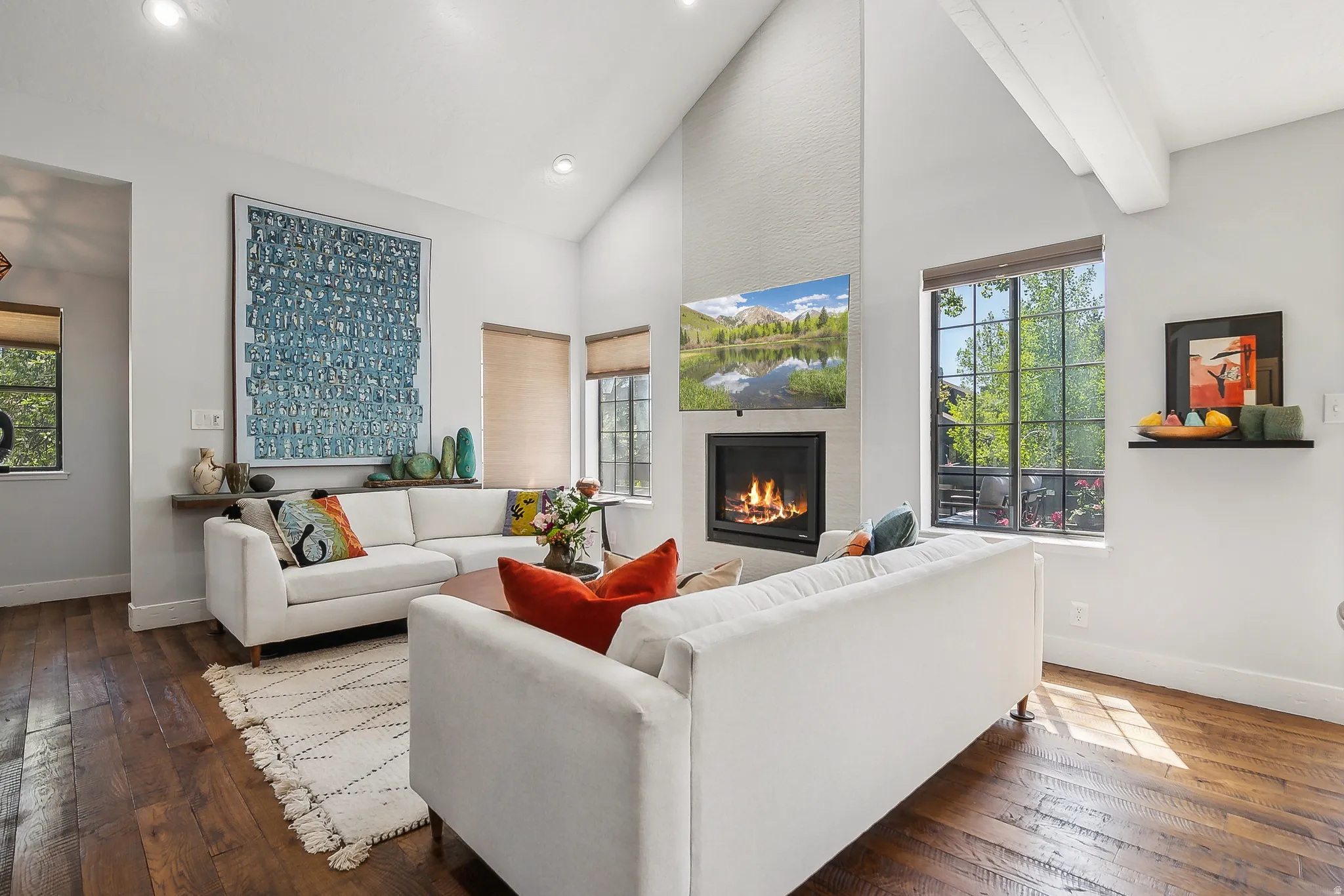 Living area featuring vaulted ceilings with exposed beams, recessed lighting, and rich wood-finish flooring.  The two couches are removed, call for details.