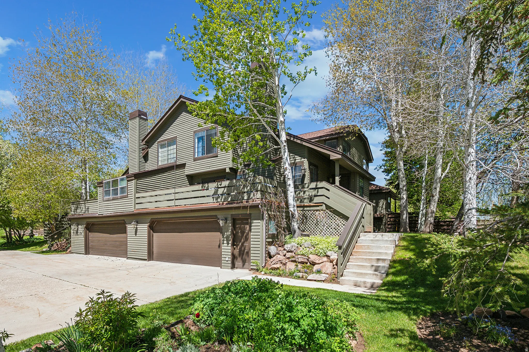 Multi-level exterior with horizontal siding and a prominent chimney