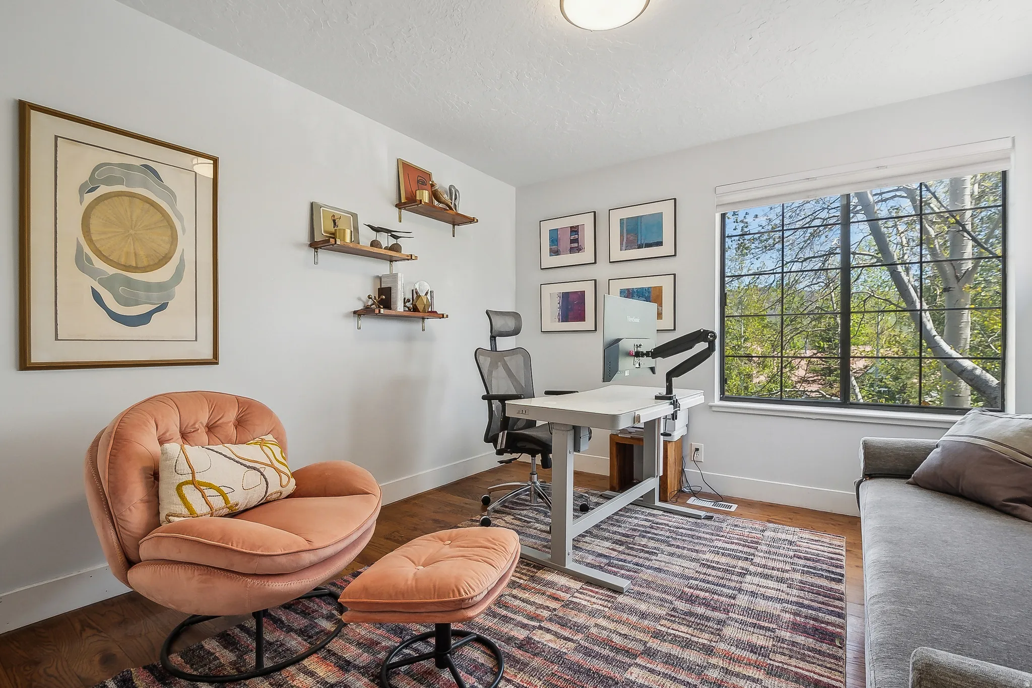 Spacious room featuring wood-finish flooring, a large window with black grilles, and recessed ceiling lighting