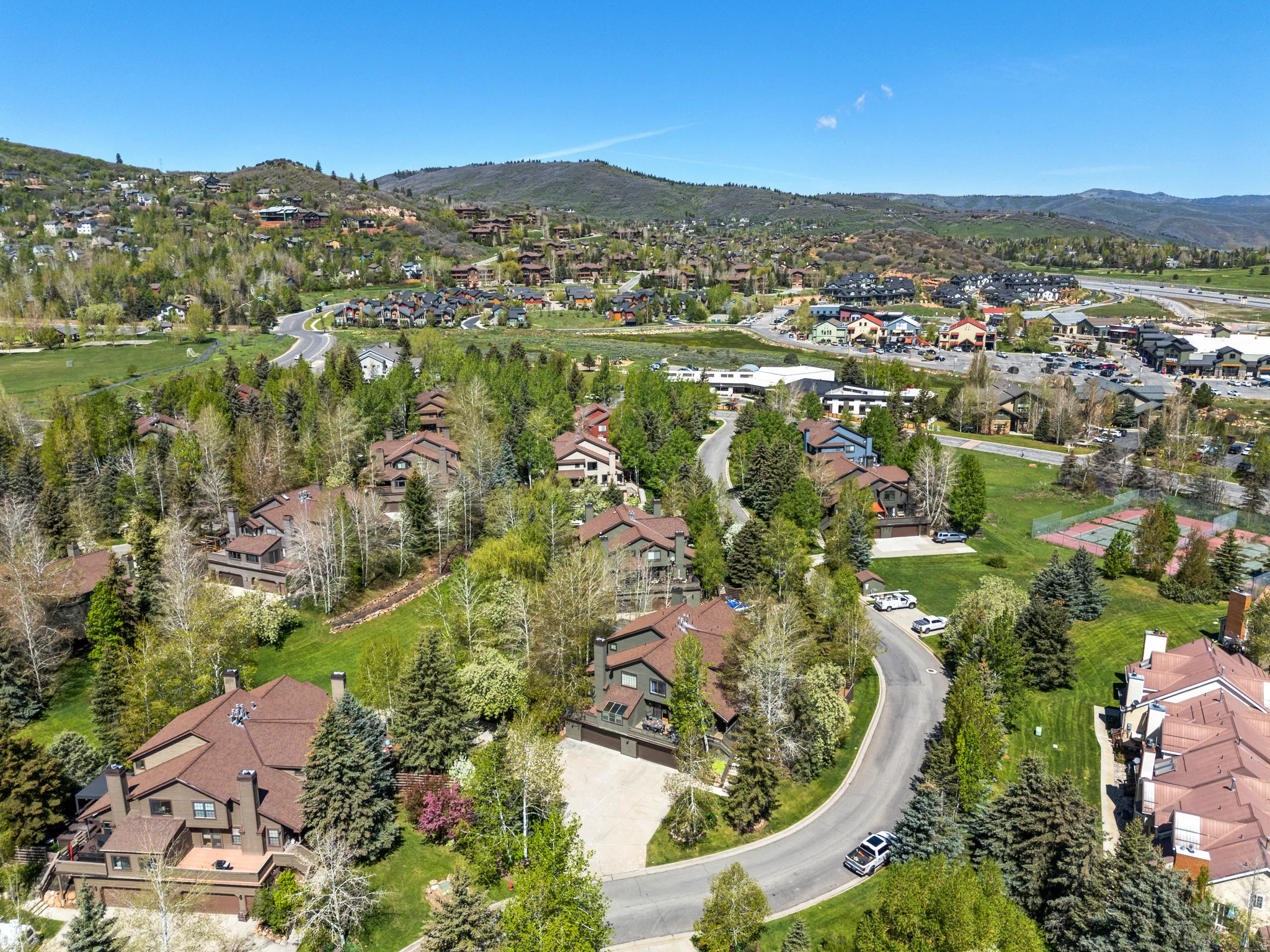 Aerial perspective showcasing a residential community nestled among mature trees and rolling hills