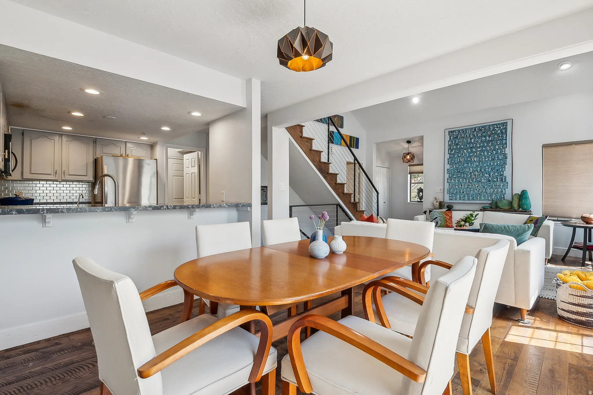 Dining area featuring wood-finish flooring and a contemporary pendant light fixture.  The two couches are removed, call for details.