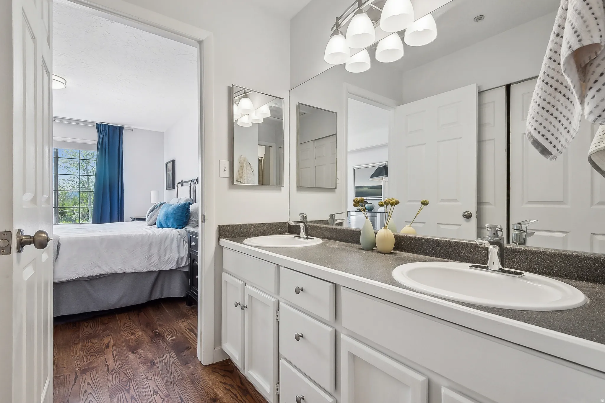 Double vanity with white cabinetry, integrated sinks, and a speckled countertop