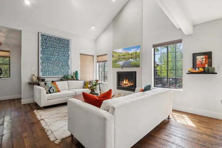 Living area featuring vaulted ceilings with exposed beams, recessed lighting, and rich wood-finish flooring.  The two couches are removed, call for details.