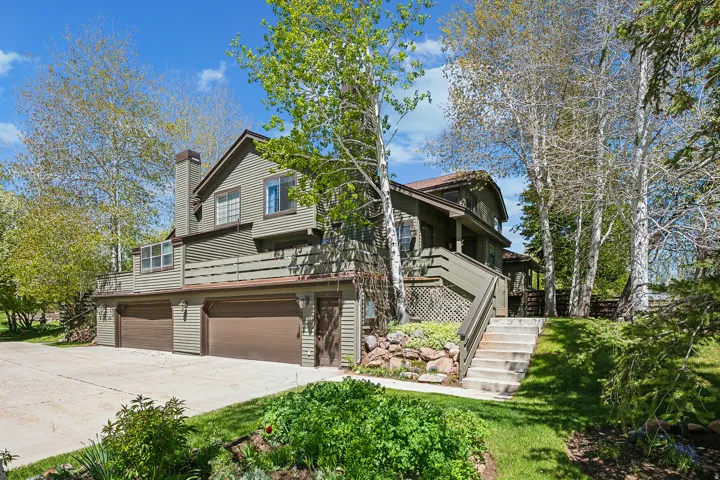 Multi-level exterior with horizontal siding and a prominent chimney