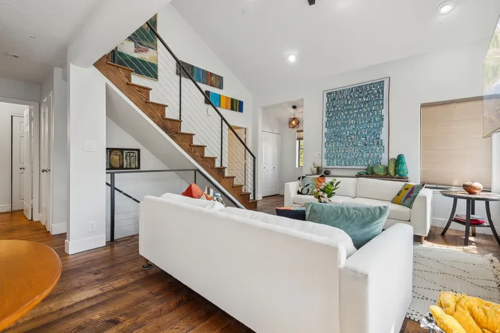 Bright living area featuring wood-finish flooring, recessed lighting, and a vaulted ceiling.  The two couches are removed, call for details.