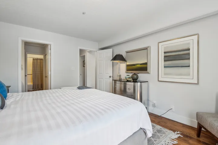 Bedroom featuring light gray wall paint, wood-finish flooring, white baseboards, and white interior doors.  Bed is removed, call for details.