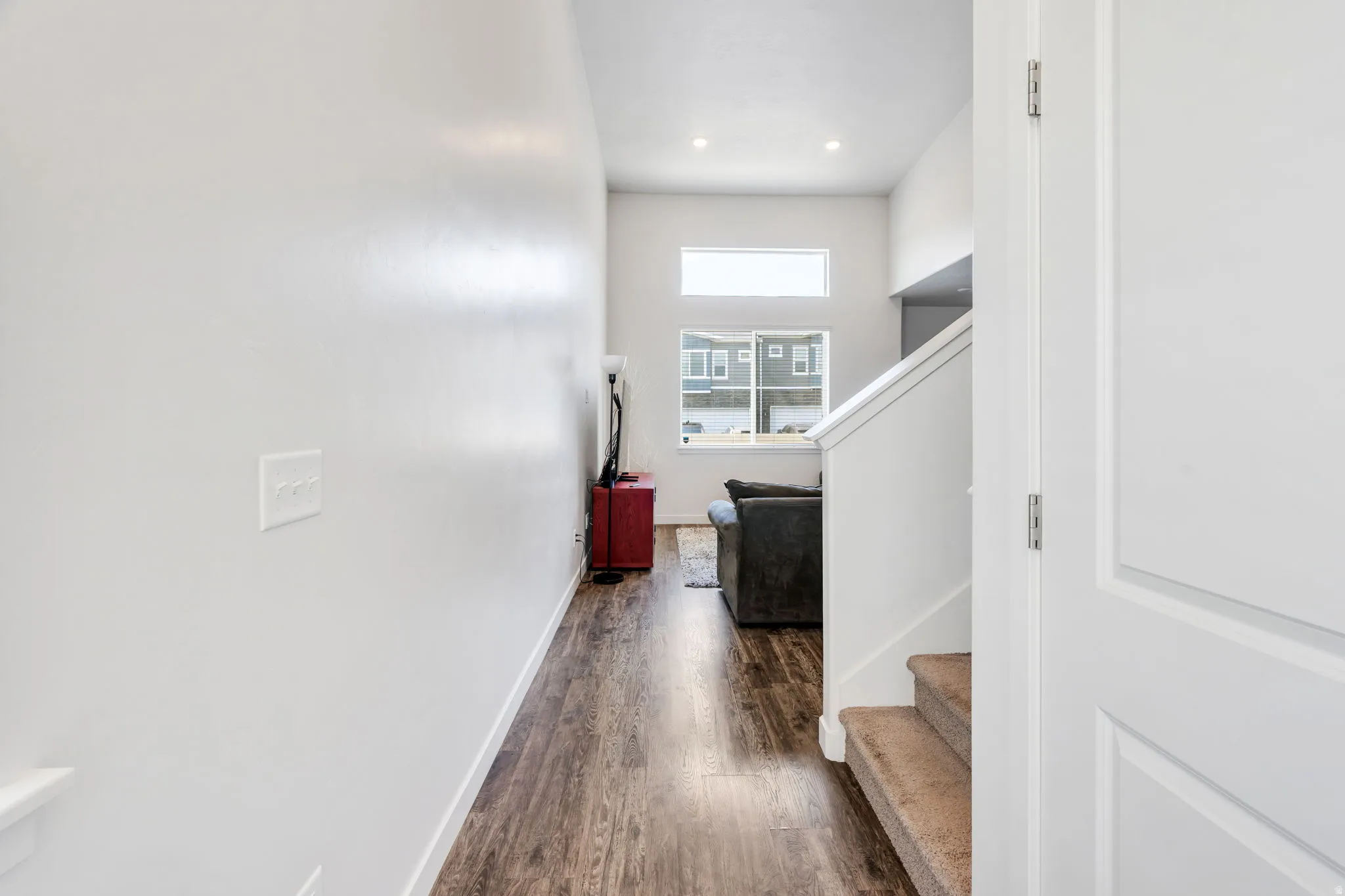 Spacious interior featuring wood-finish flooring, white walls, and recessed lighting