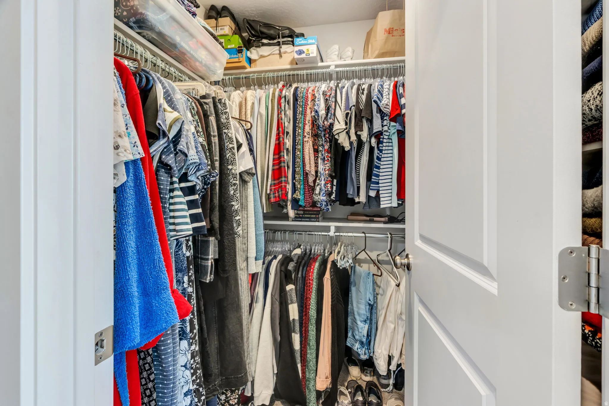 Walk-in closet with wire shelving and multiple hanging rods for optimized storage