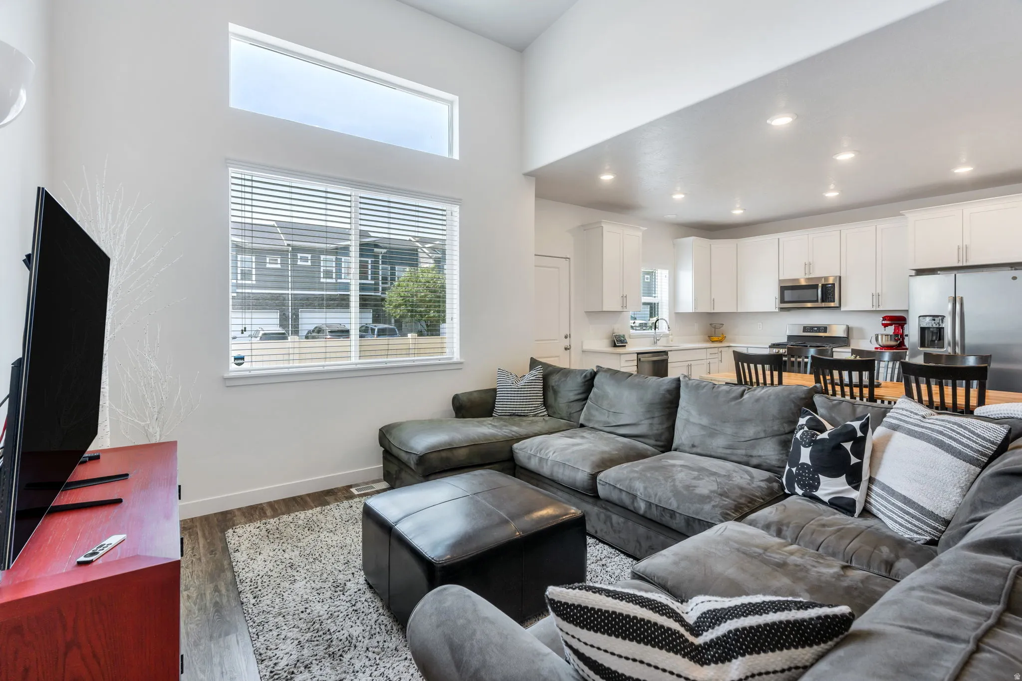 Open-concept living area with high ceilings and wood-finish flooring