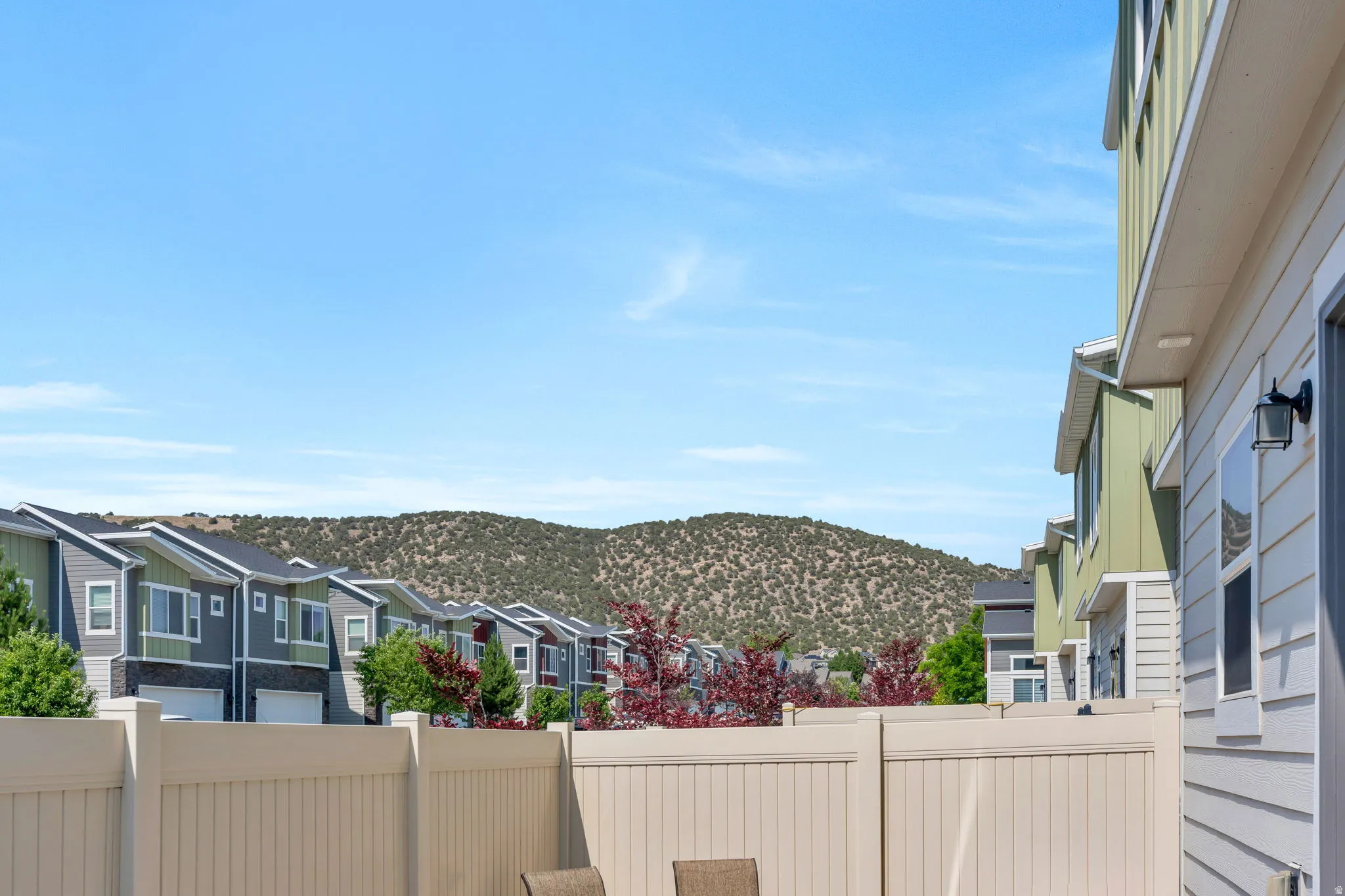 Exterior patio area featuring a light-toned privacy fence and modern house siding