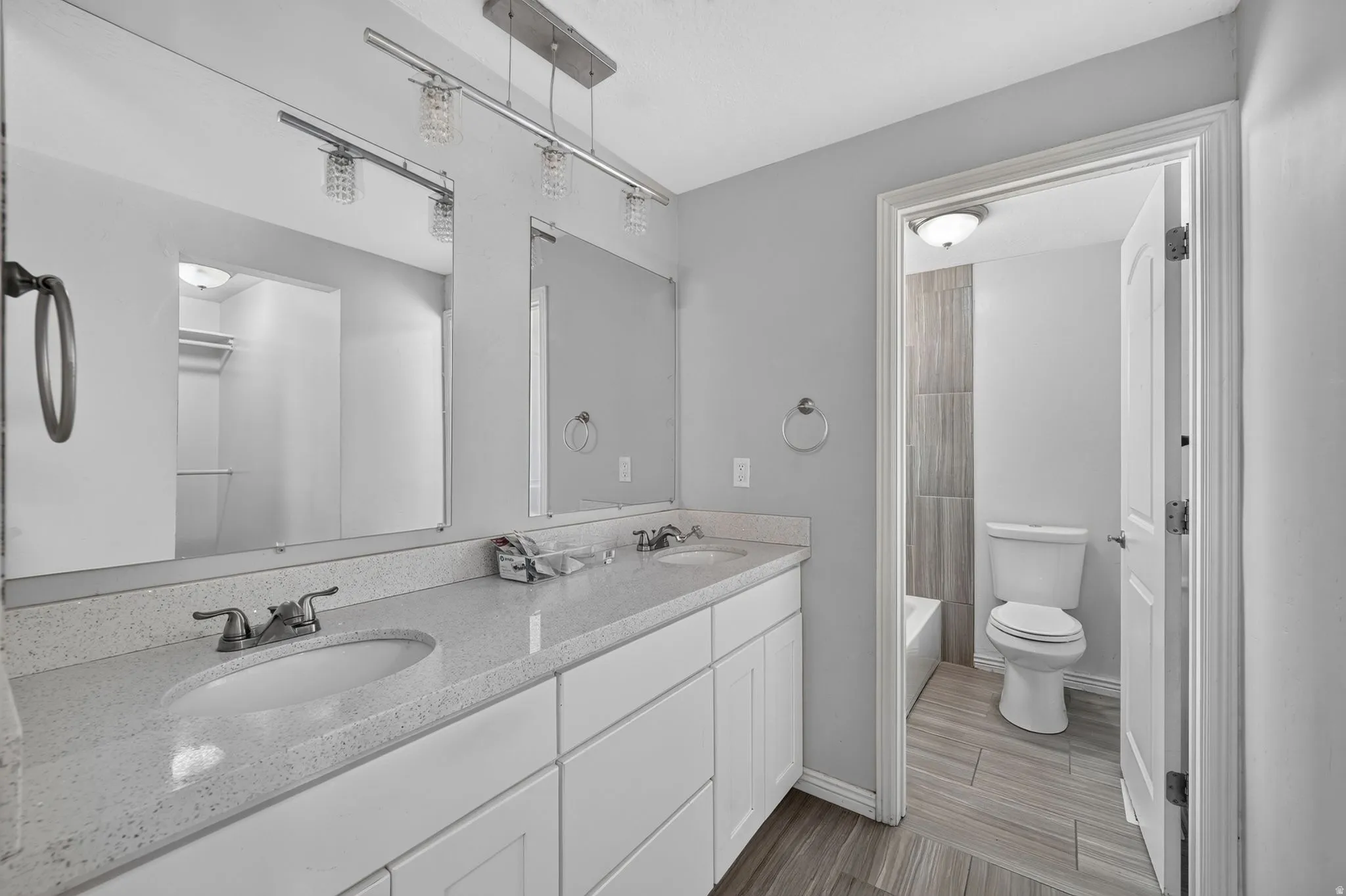 Damily bathroom Double vanity with speckled countertop and white cabinetry