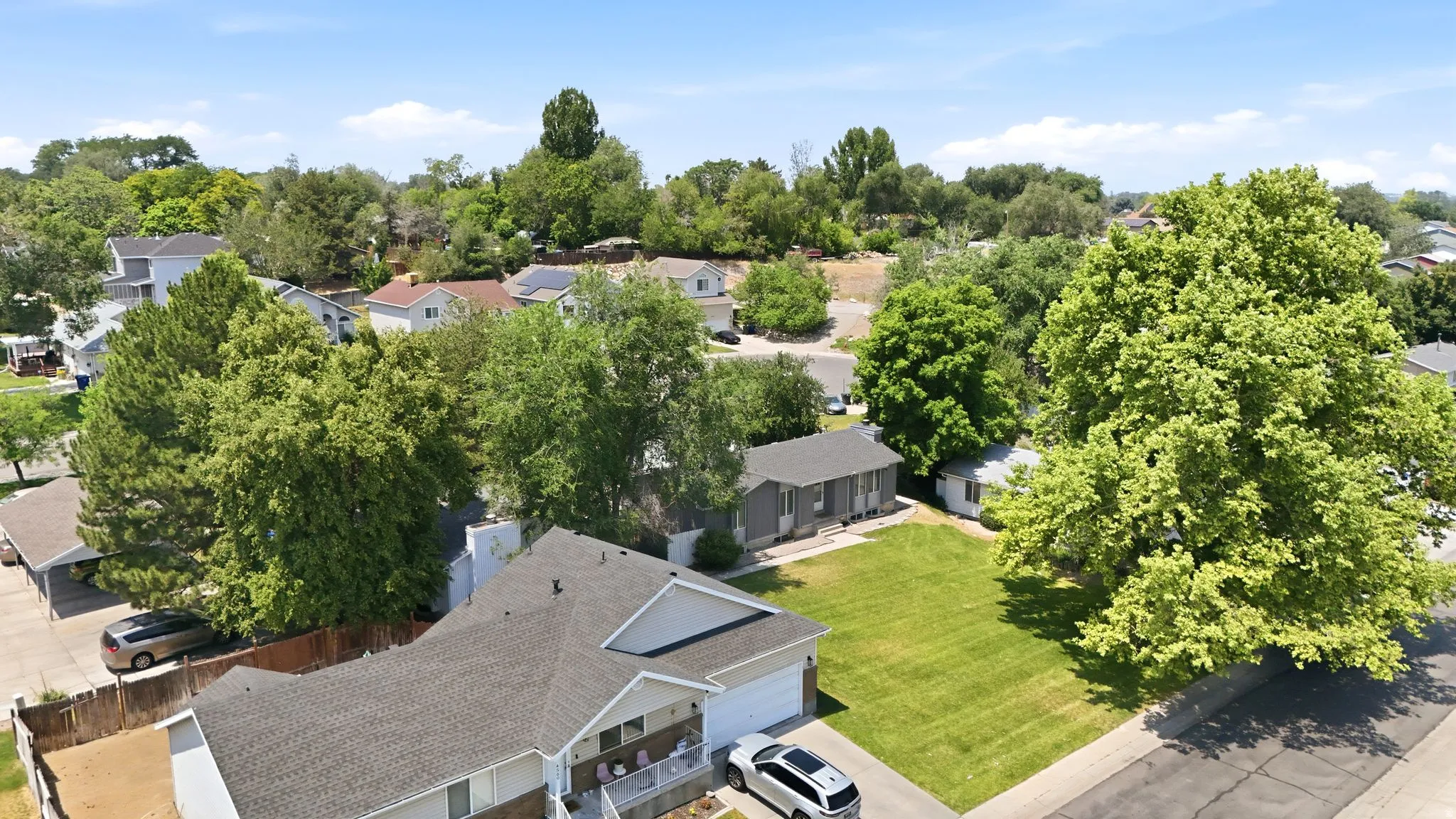 Aerial perspective showcasing a residential street with mature trees and established landscaping