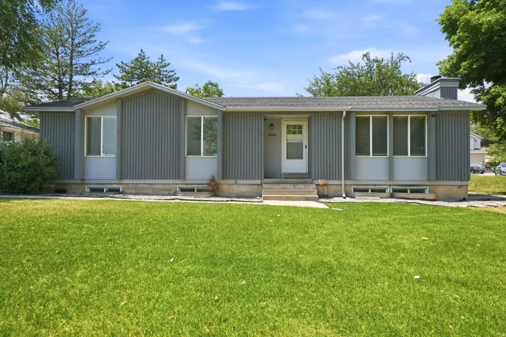 Single-story residence featuring gray vertical panel siding and a light gray trim