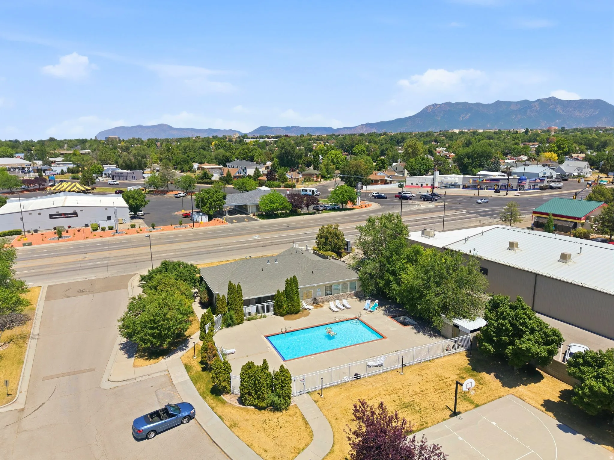 Outdoor swimming pool with surrounding fence and paved patio