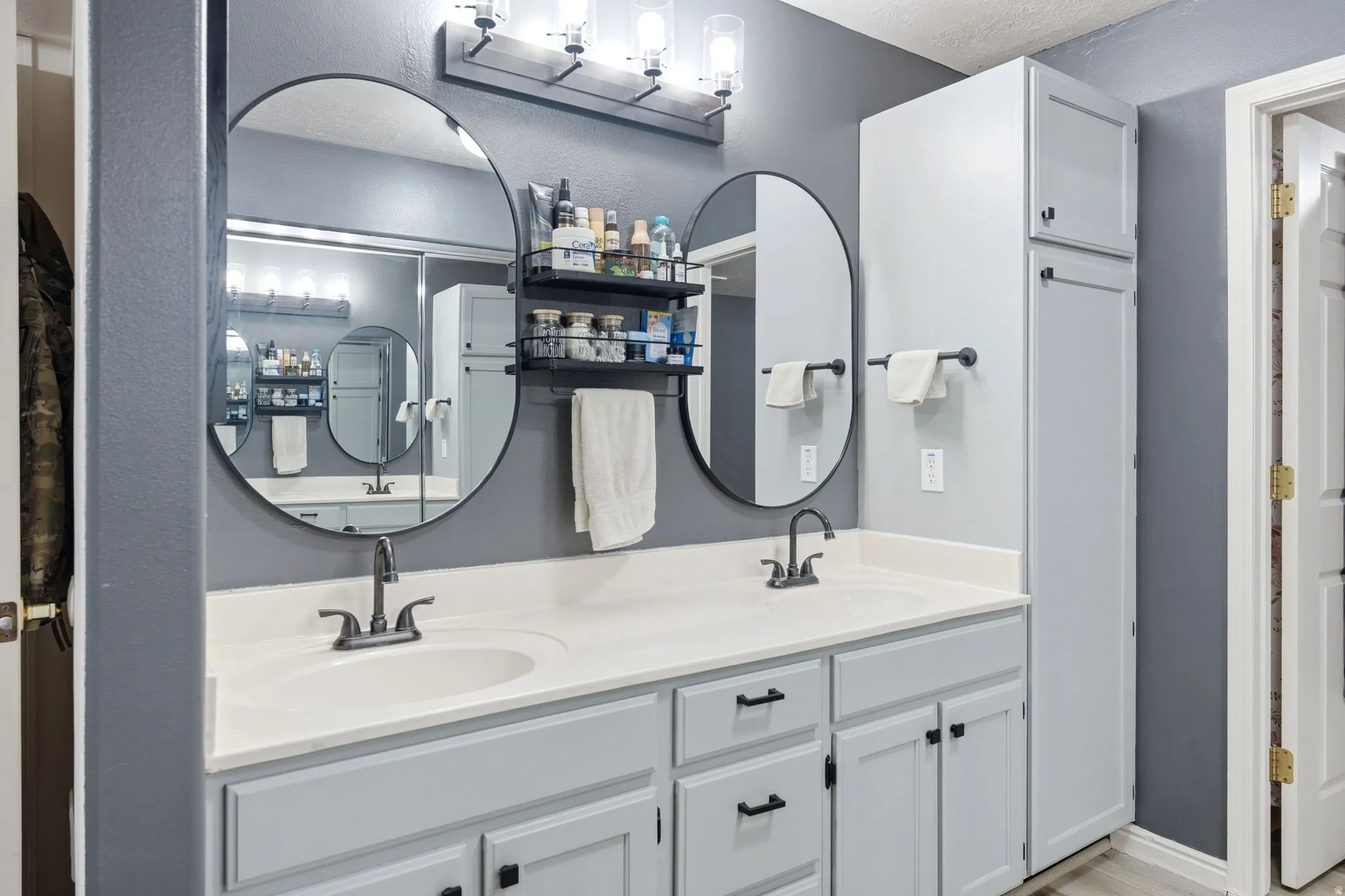 Master bath with a double vanity with light gray cabinetry and white countertops