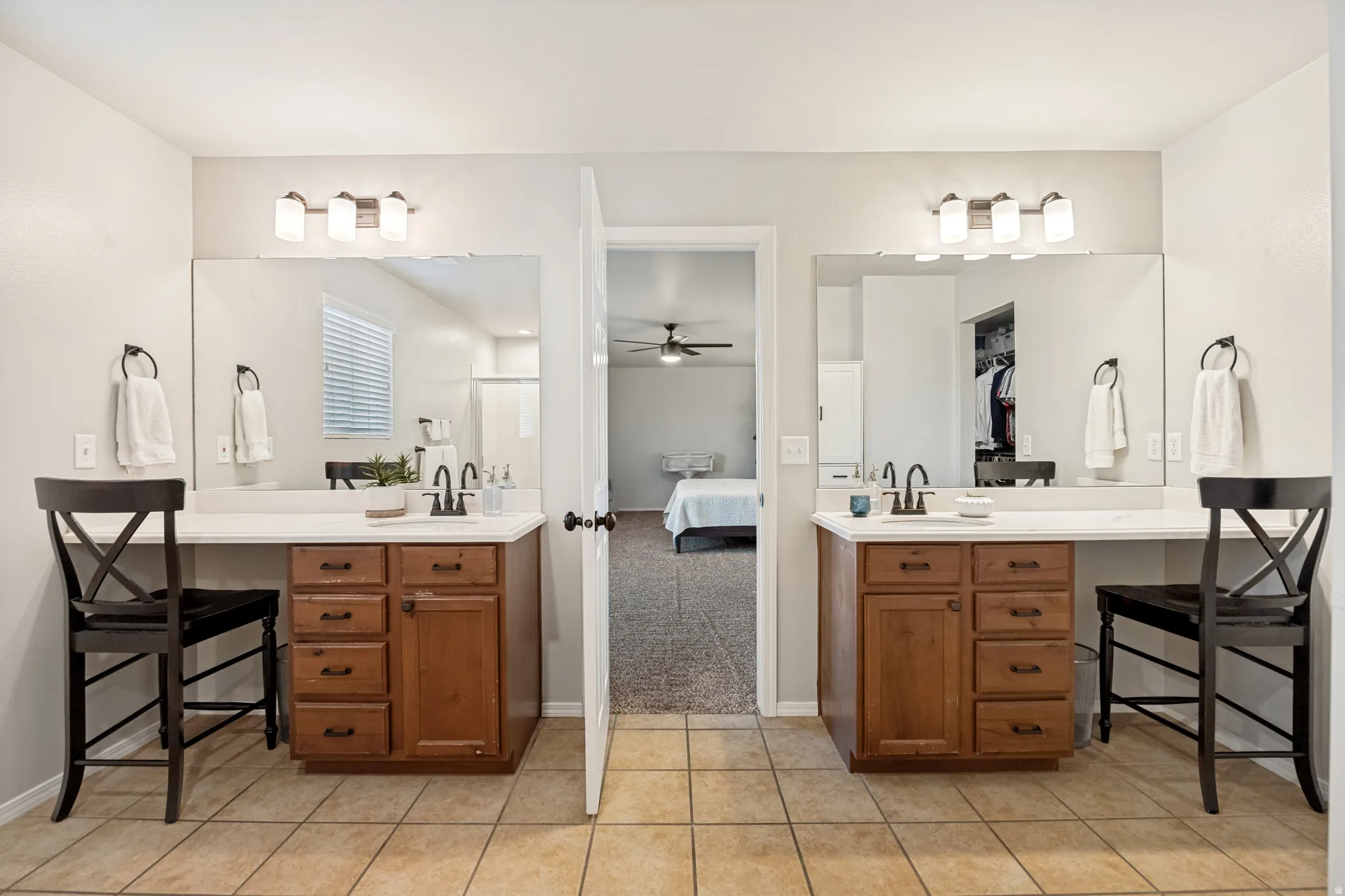 Dual vanity featuring wood-finish cabinetry and light countertops
