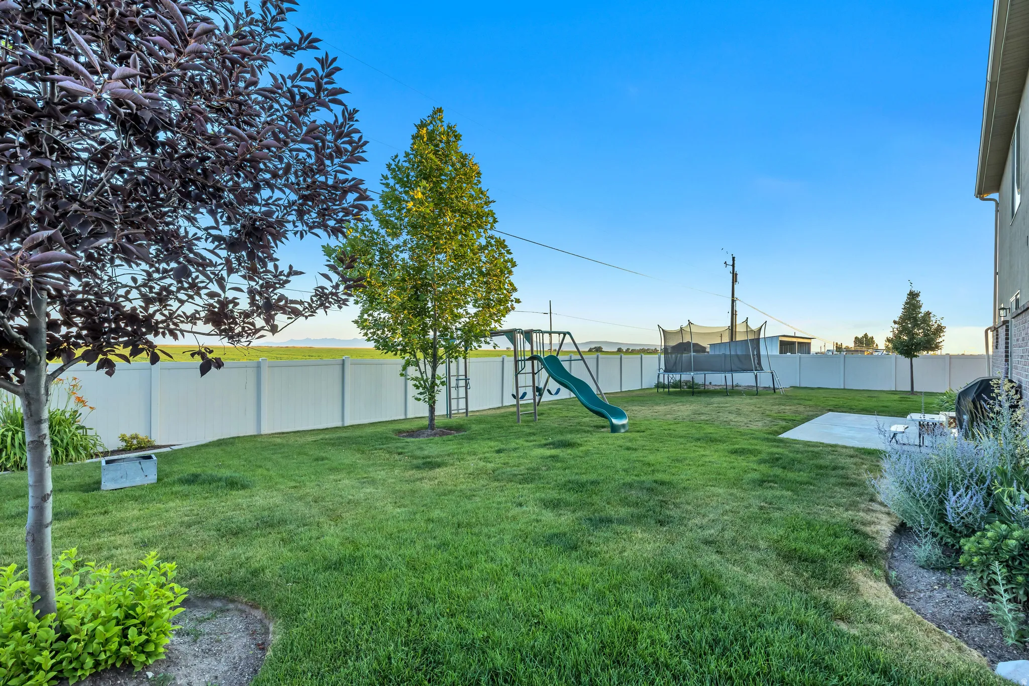 Spacious backyard featuring a manicured lawn, a concrete patio, and a privacy fence