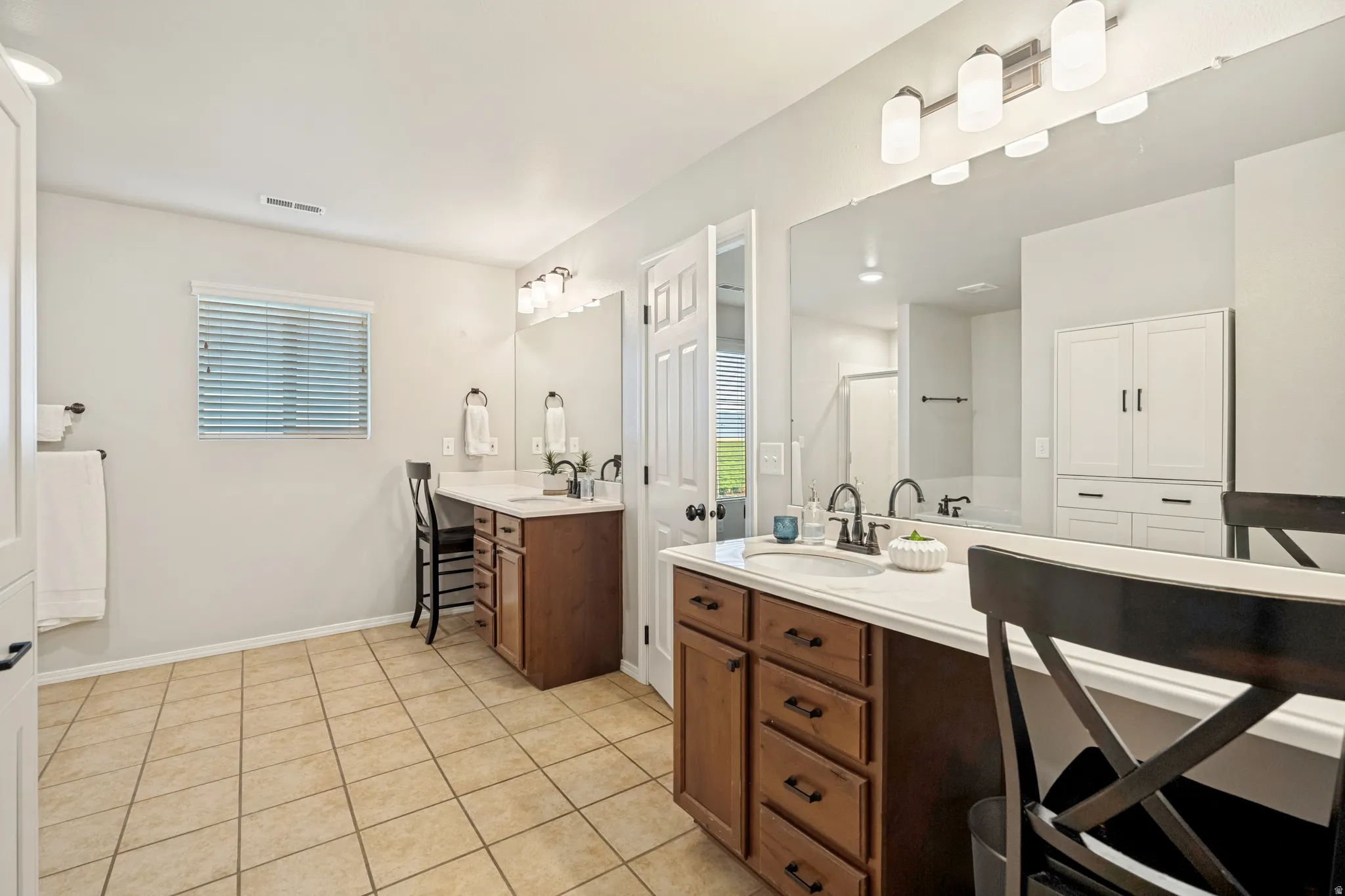 Dual wood-finish vanities with light countertops and undermount sinks