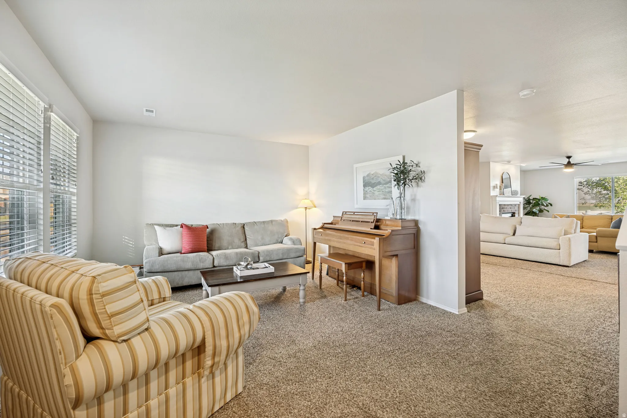 Carpeted living area with white walls and natural light