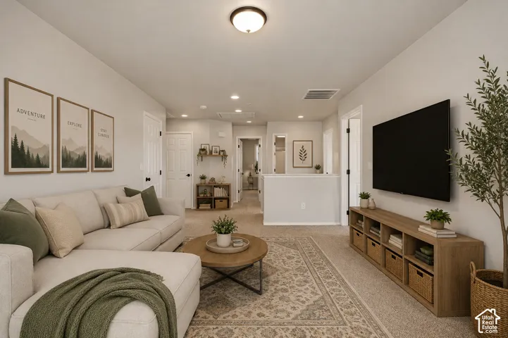 Carpeted living area with a ceiling-mounted light fixture and recessed lighting, featuring a partial wall with a half-wall partition