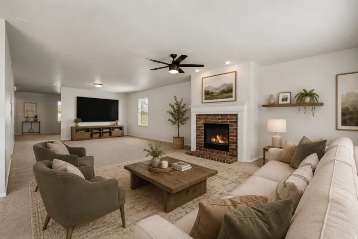 Spacious living area featuring a brick-surround fireplace with a white mantel, ceiling fan, and recessed lighting