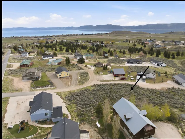 Expansive lot with a natural landscape, offering a broad perspective of the surrounding homes and distant lake