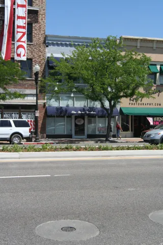 Commercial building with a blue awning, street-level display windows, and a prominent front entrance