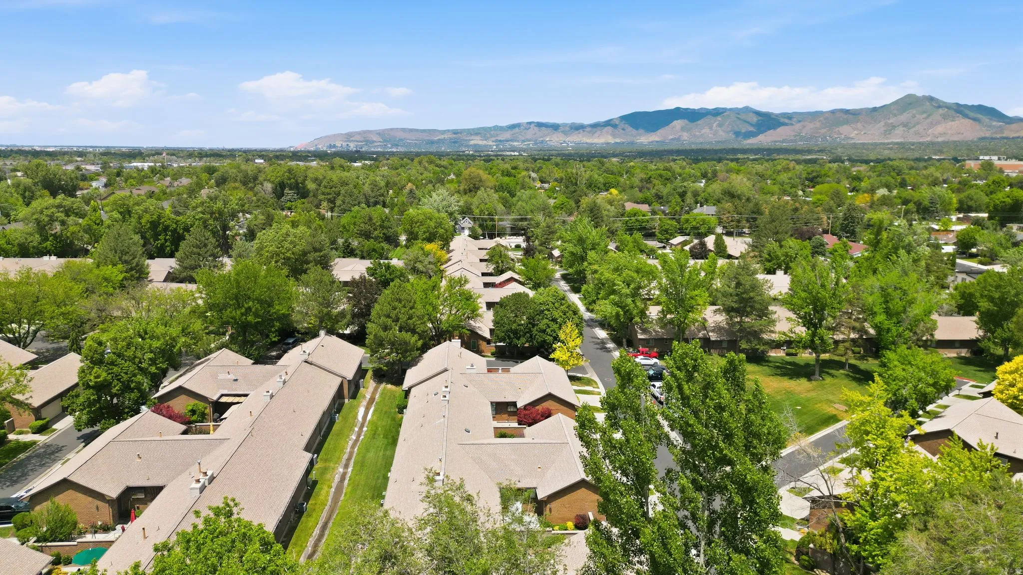 Aerial perspective of a residential neighborhood featuring multiple unit structures with light-colored roofing