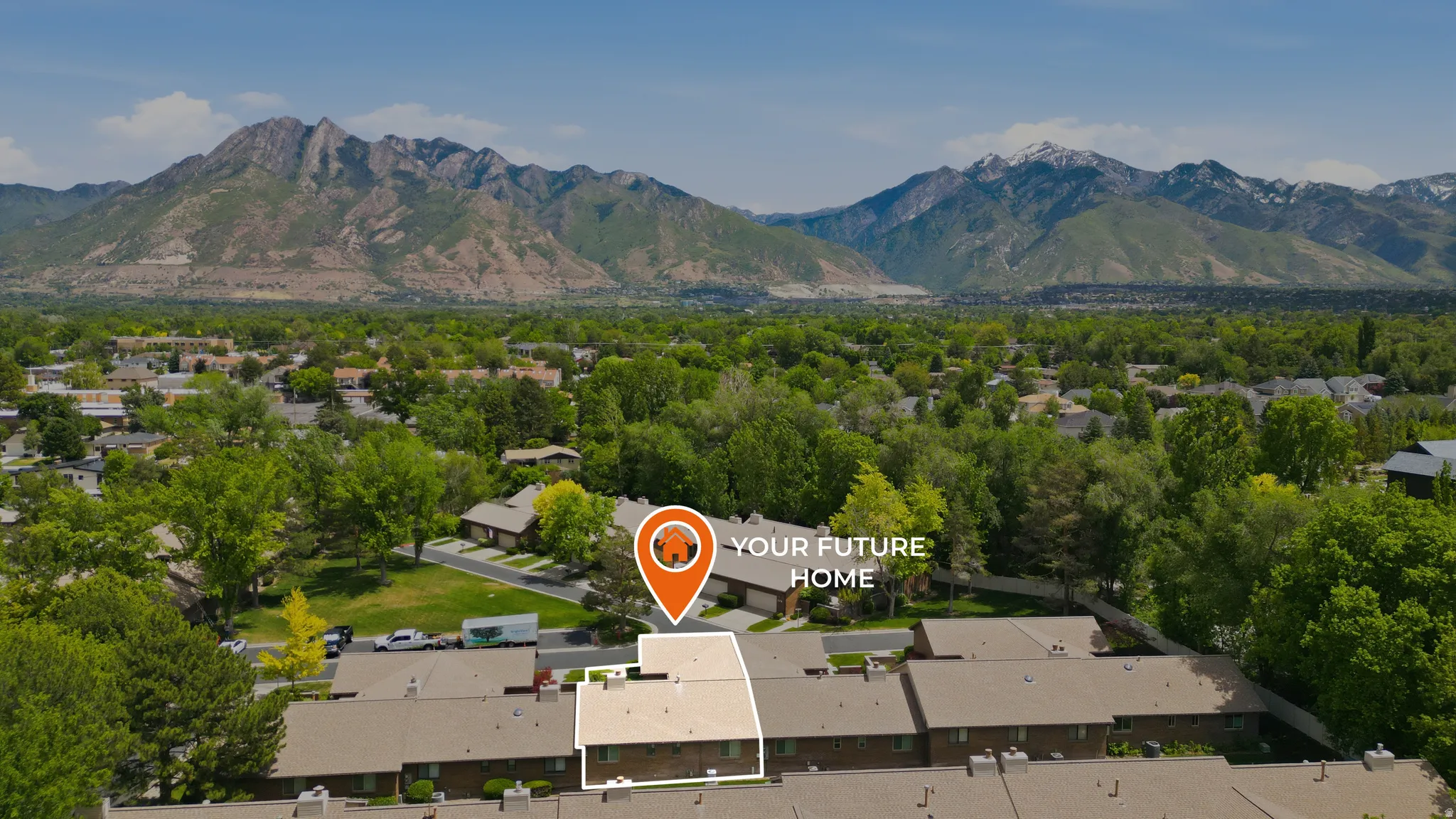 Townhome property situated within a community of residences, surrounded by mature trees and lush greenery