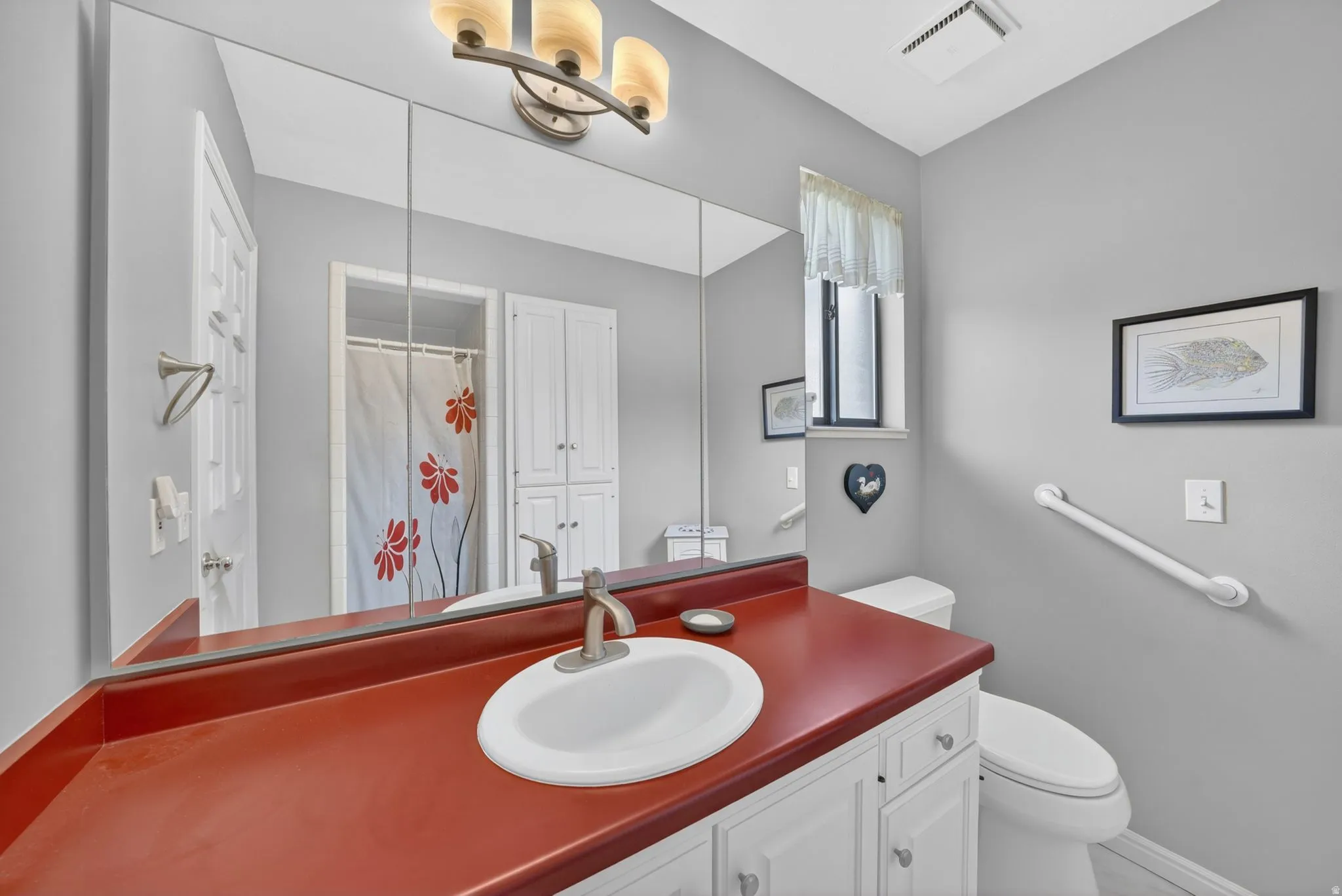 Vanity with a rich red countertop and integrated sink