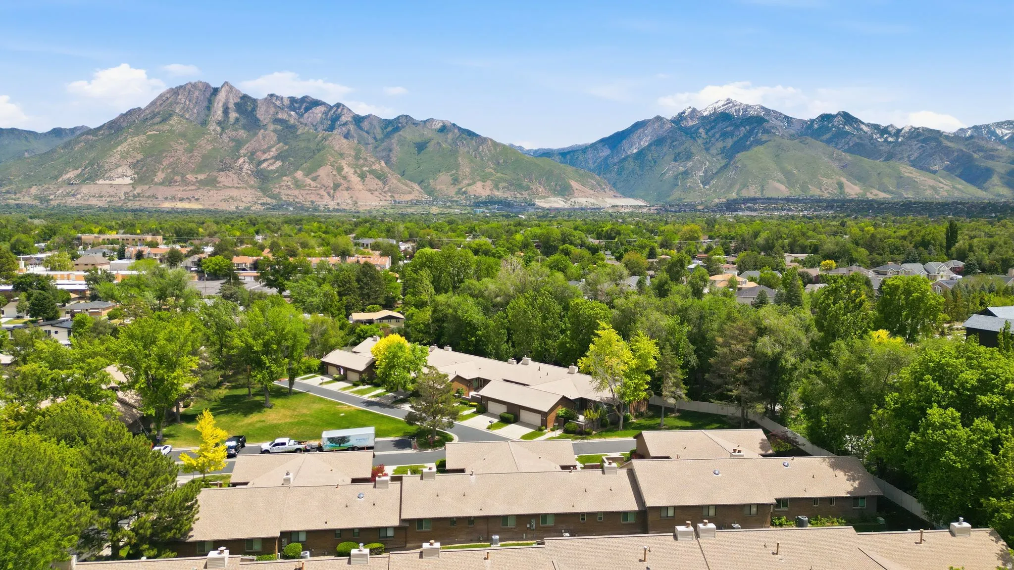 Expansive mountain range backdrop framing a verdant, tree-filled landscape