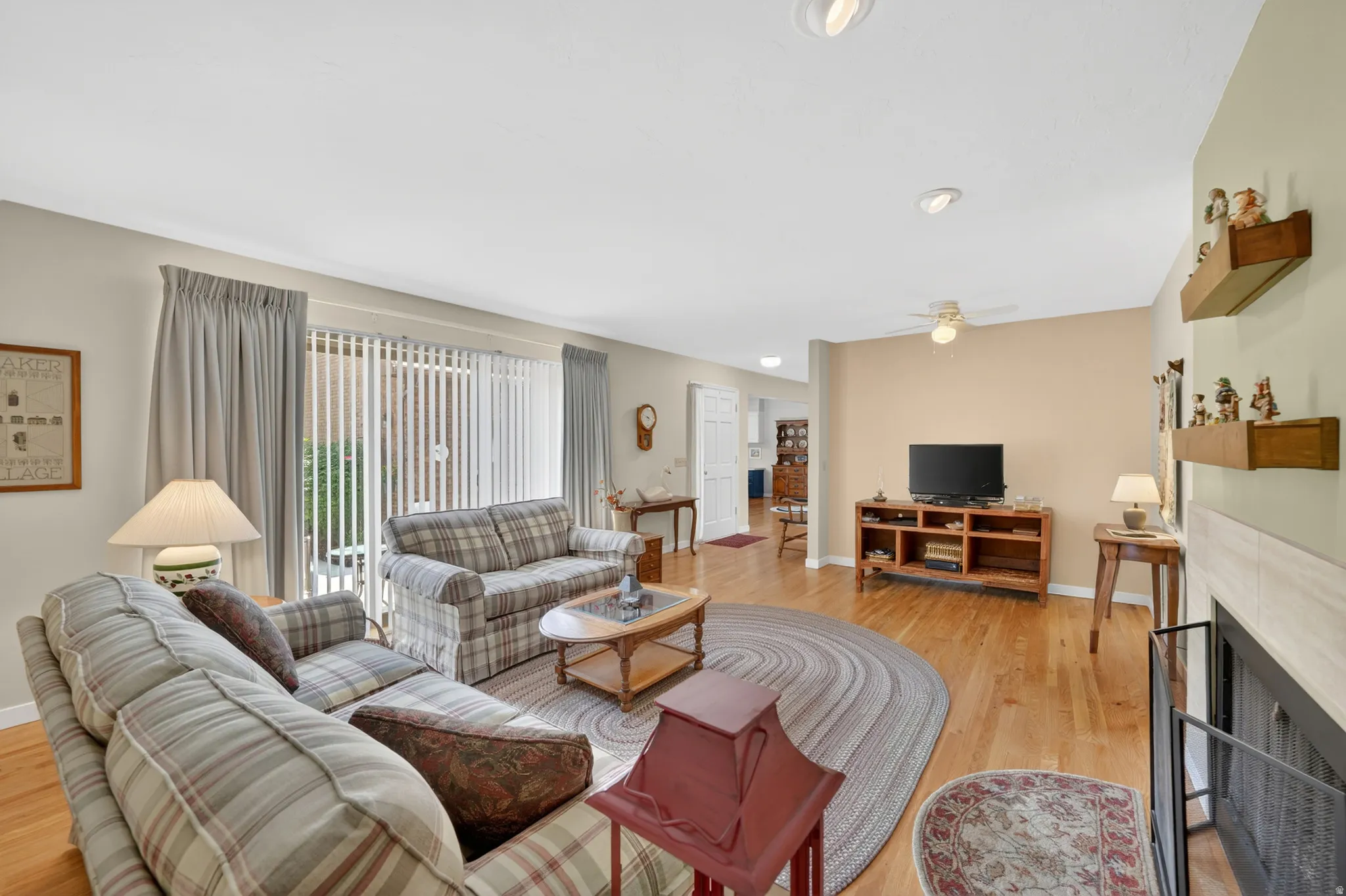 Living area featuring natural oak wood flooring, recessed lighting, a ceiling fan and slider door leading to outside patio area