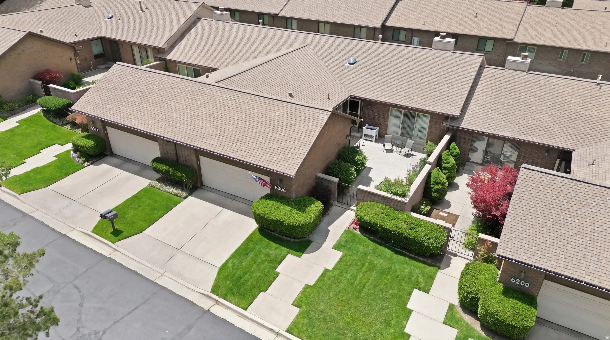 Brick exterior with a shingle roof and front-facing garage doors