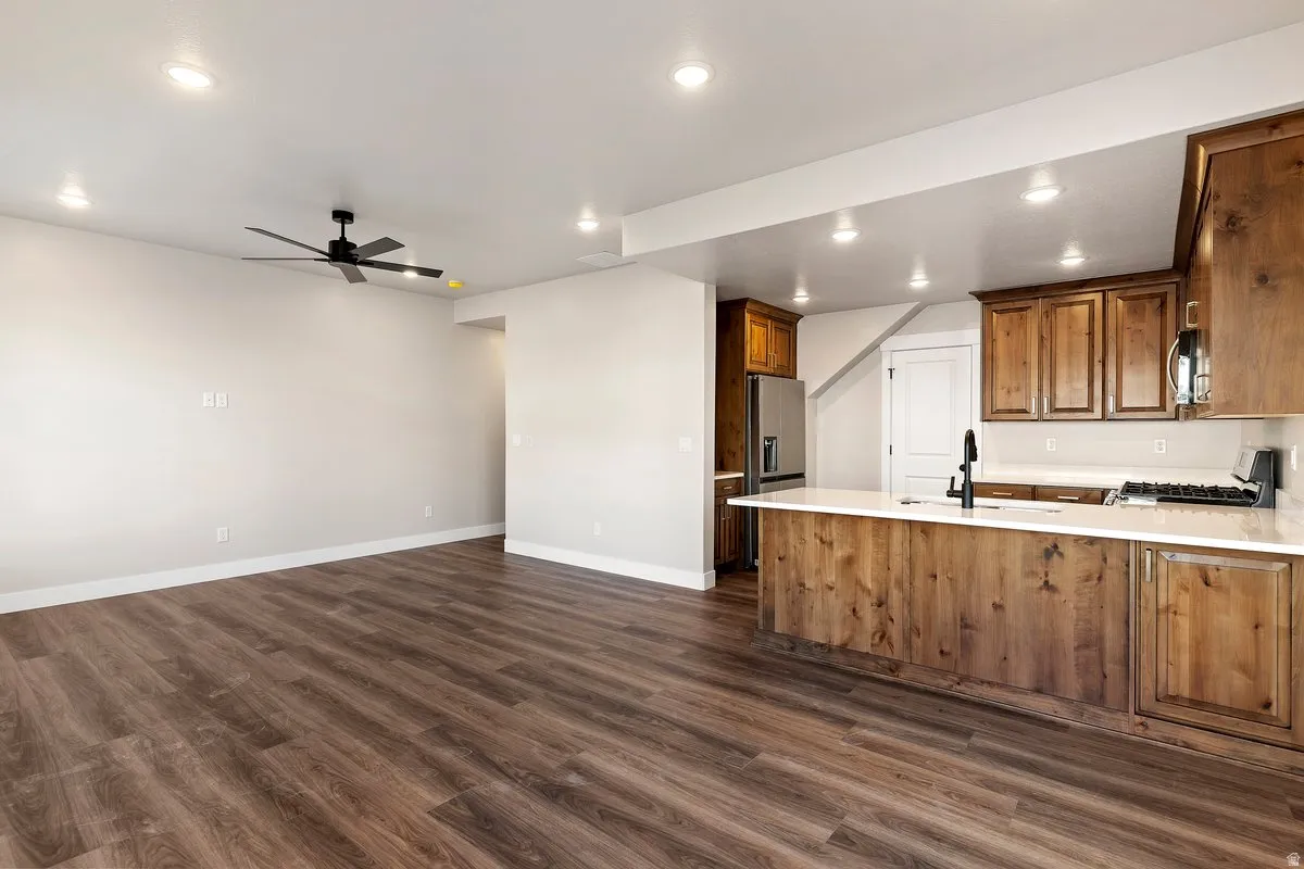 Open-concept living area featuring wood-finish flooring, recessed lighting, and a contemporary ceiling fan