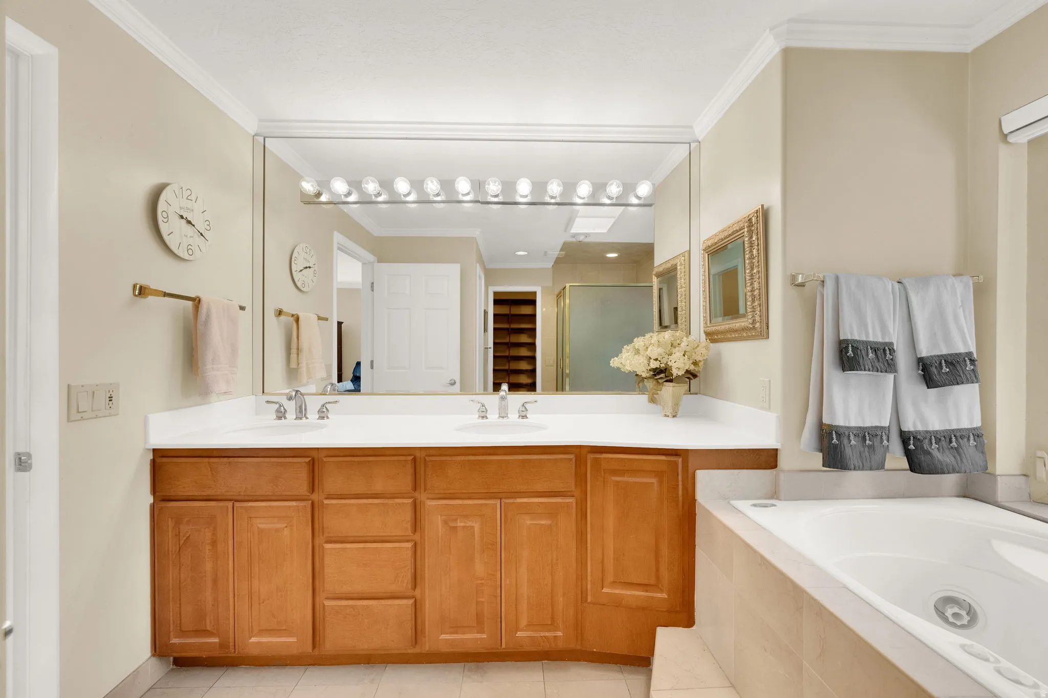 Double vanity with wood-finish cabinetry, white countertops, and dual sinks