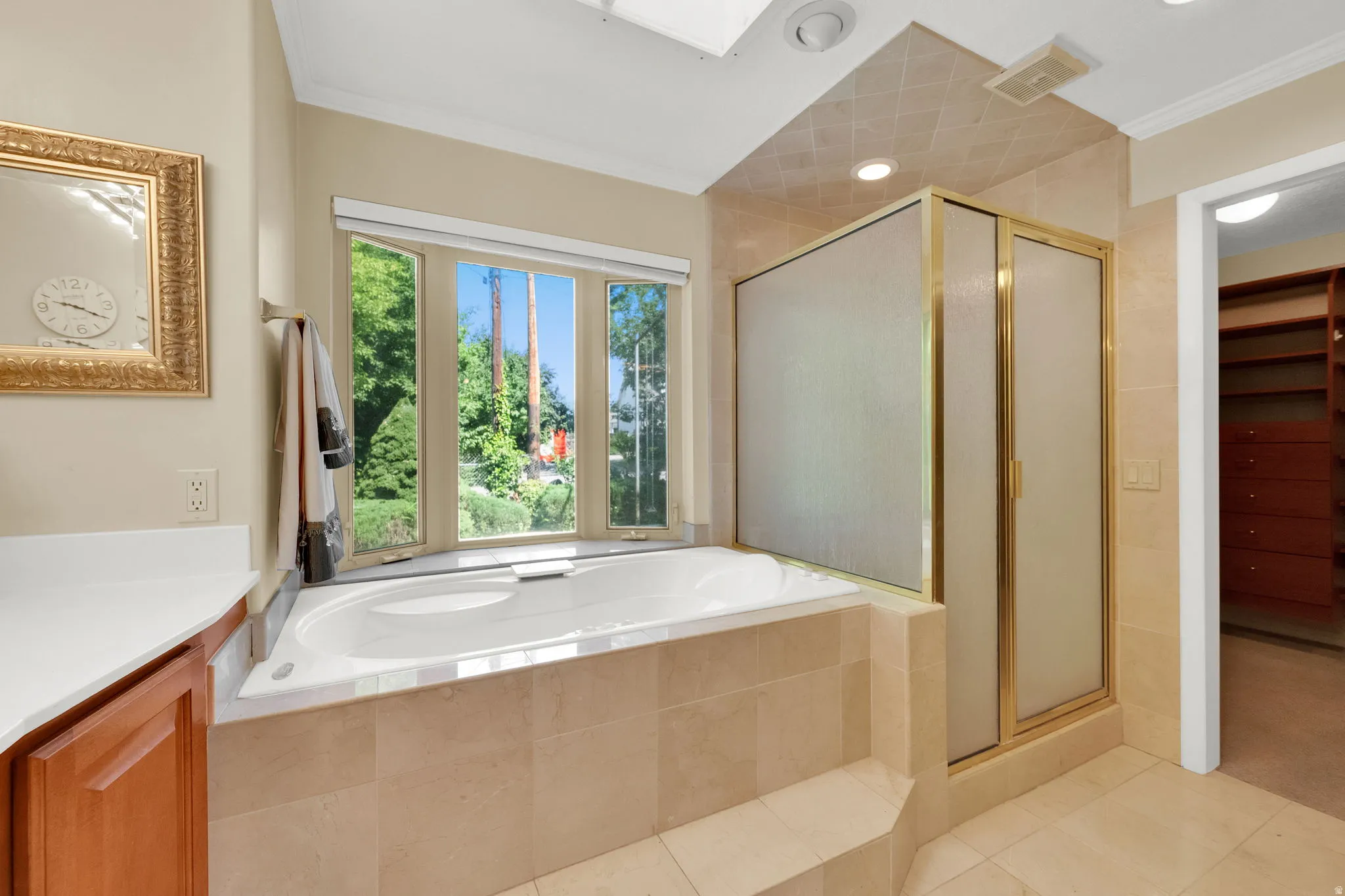 Soaking tub with a tiled surround, framed by a bay window