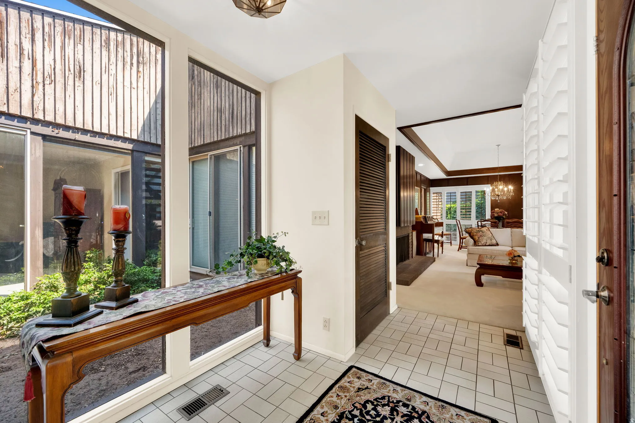 Entryway featuring light tile flooring and a vaulted ceiling