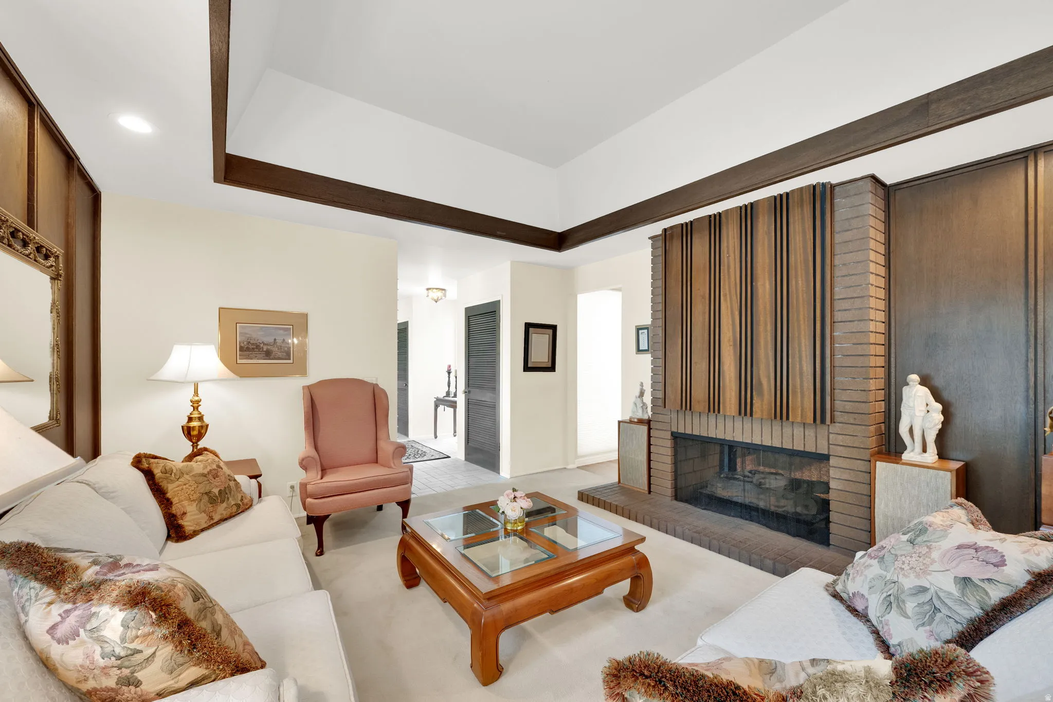 Living area featuring a prominent brick fireplace with a wood-paneled accent wall
