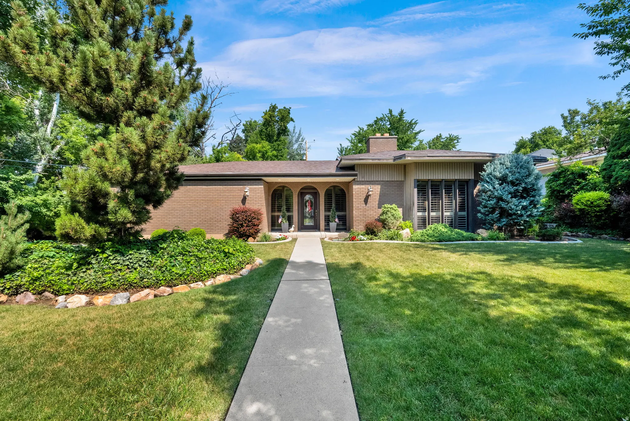 Brick exterior featuring arched entryways and a covered front porch